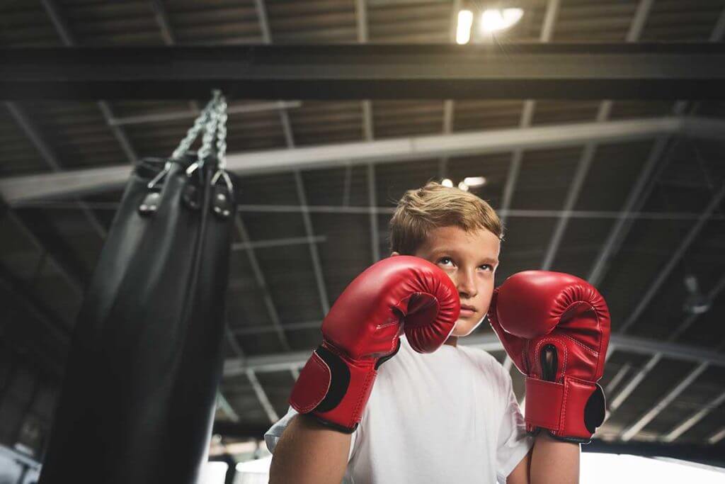 Young boy with red gloves training in Kids Beginner Kickboxing classes