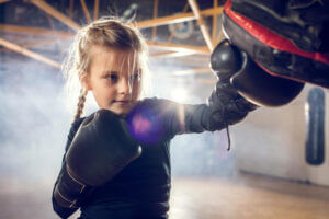 Young girl boxing with trainer