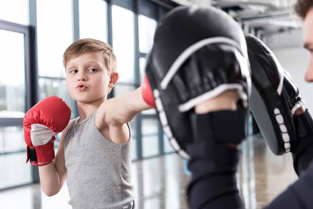 Boy boxing with a trainer